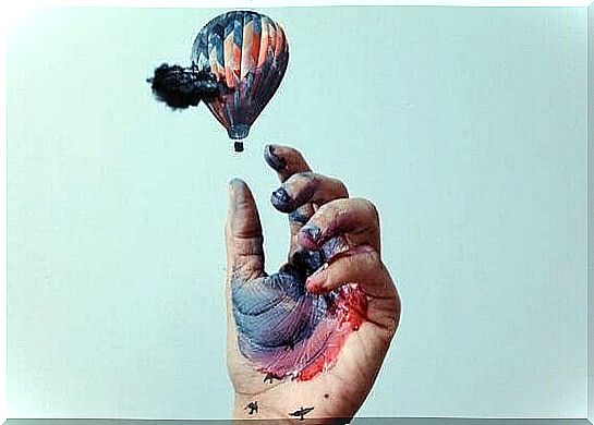 Inked hand trying to catch balloon