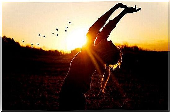 Woman celebrating at sunset